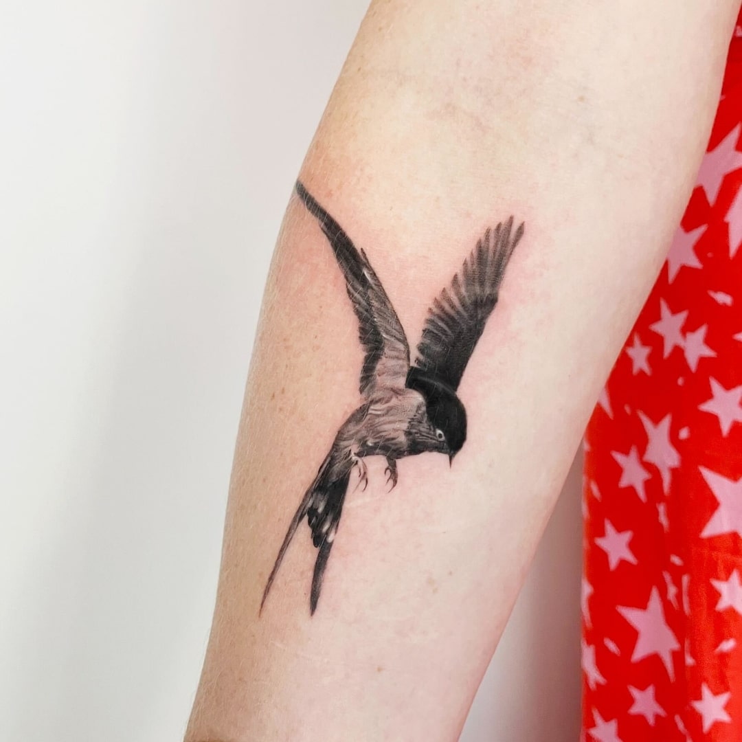 Stylized tattoo of a soaring bird on an arm