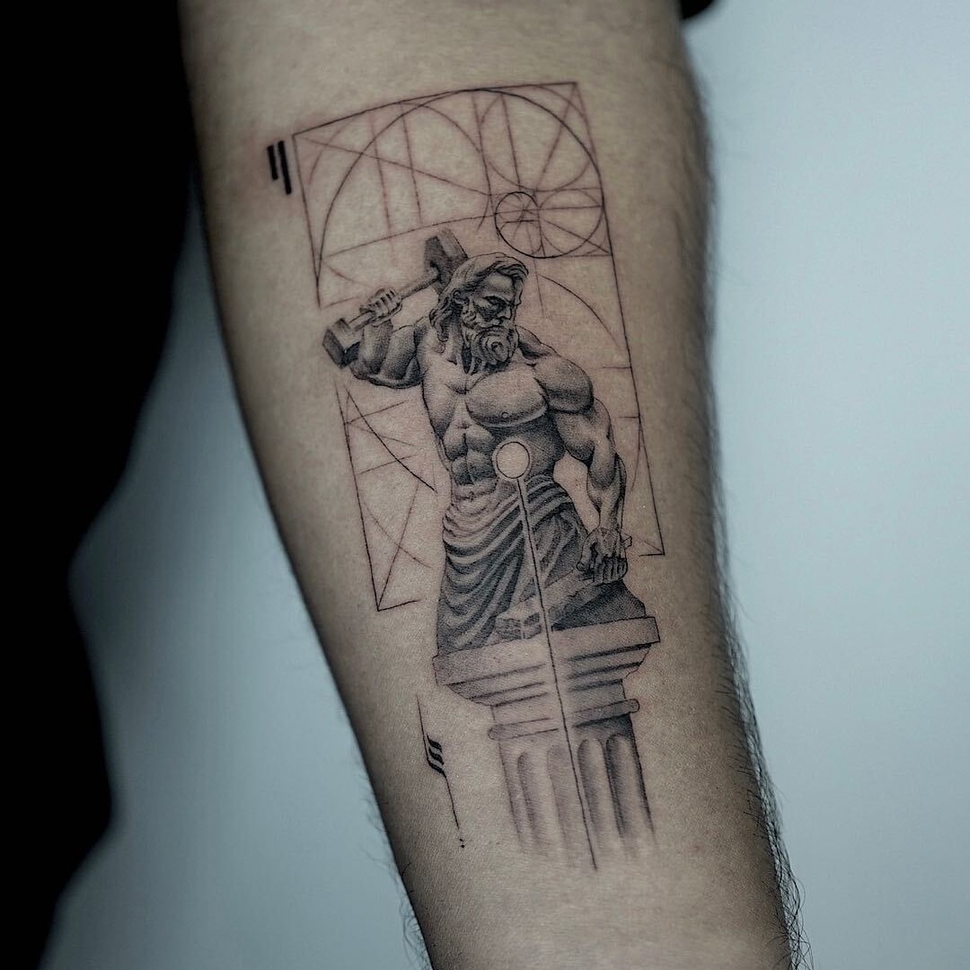 Intricate tattoo of a muscular figure holding a hammer.