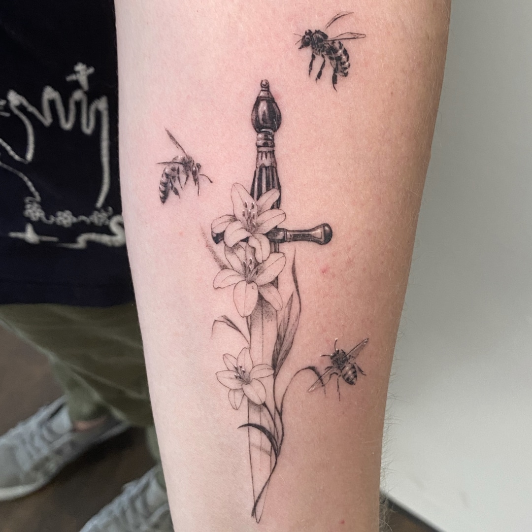 Tattoo design featuring a sword, flowers, and bees