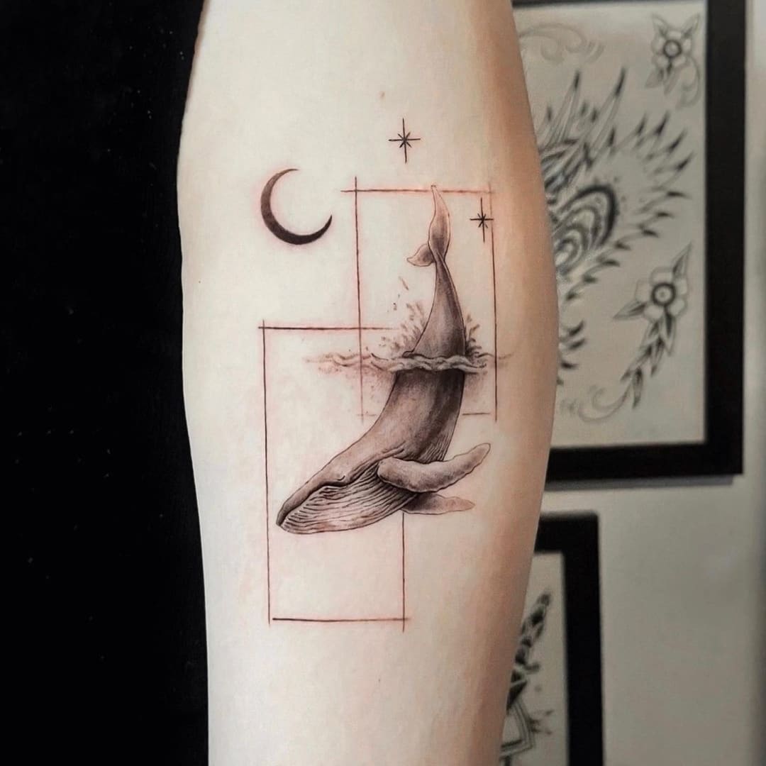 Detailed tattoo of a whale surrounded by geometric shapes.