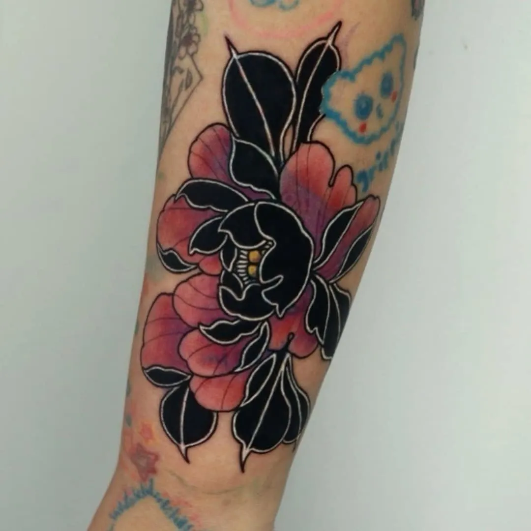 Tattoo of a black and pink flower on an arm