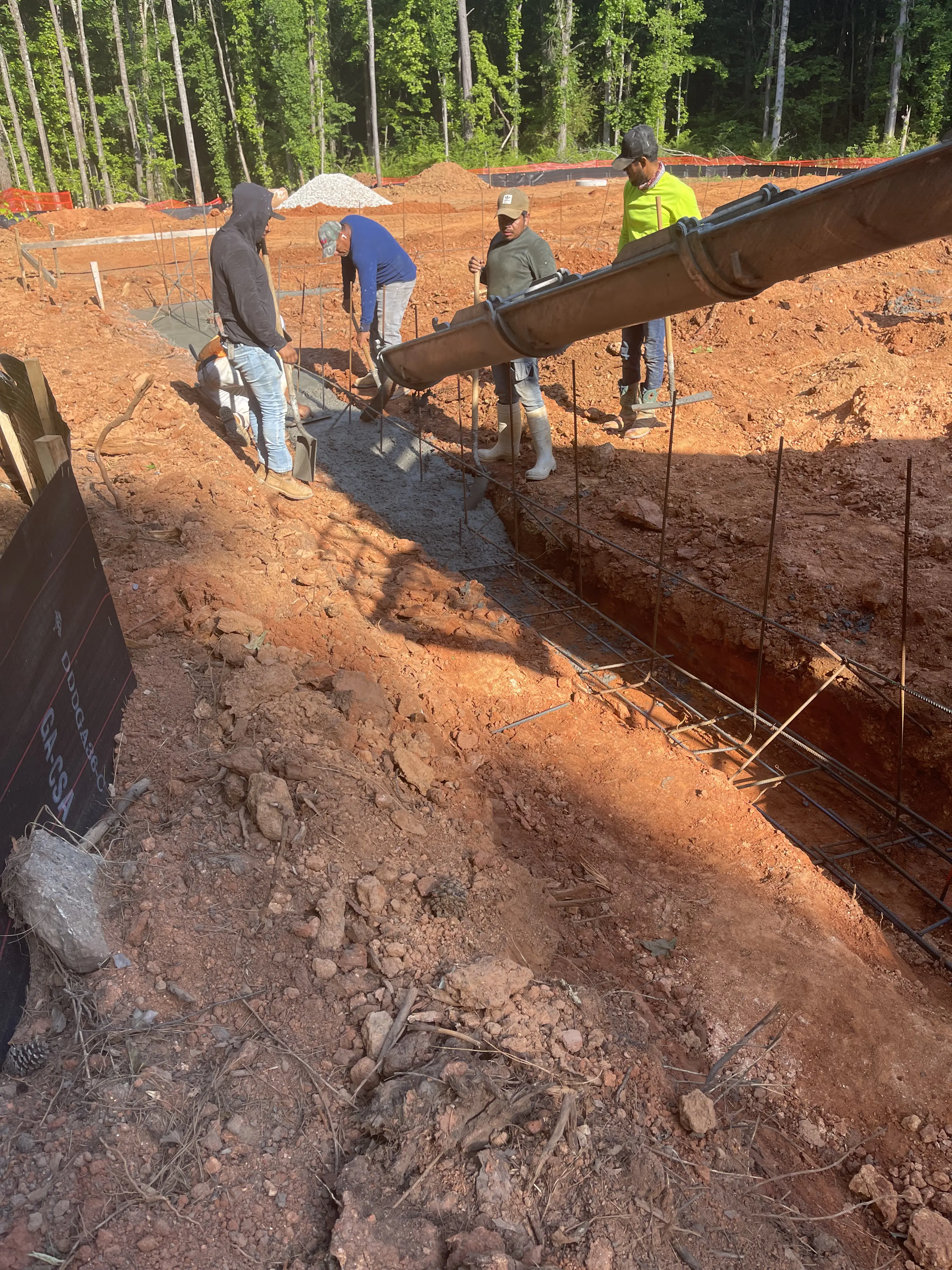 Construction workers pouring concrete into a foundation.