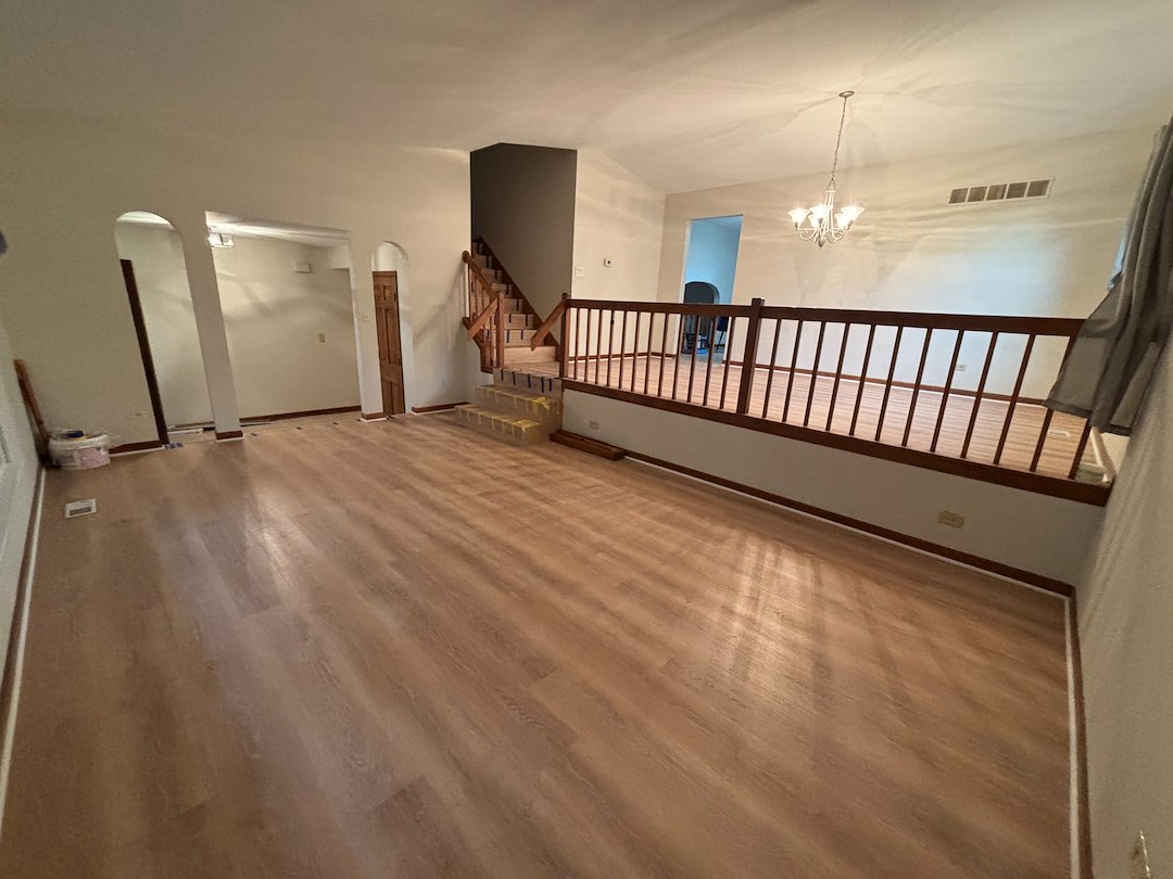 Spacious living room with staircase and wooden railing