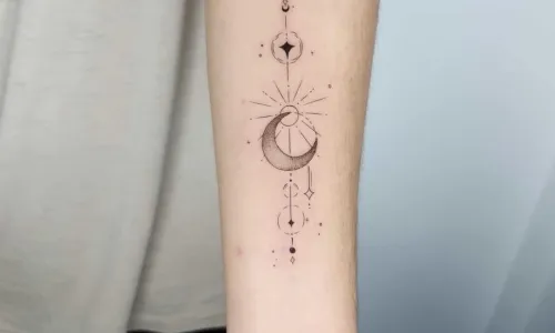 Black and grey moon tattoo on arm