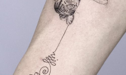 Detailed tattoo of a sleeping tiger on a forearm