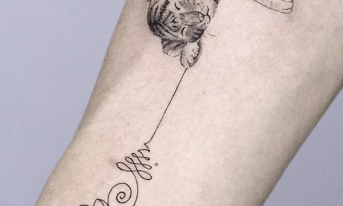 Detailed tattoo of a sleeping tiger on a forearm