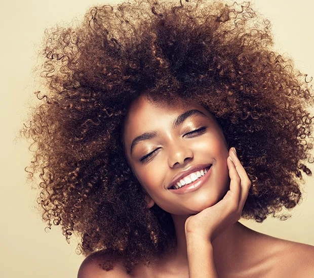 Smiling woman with curly hair on a neutral background
