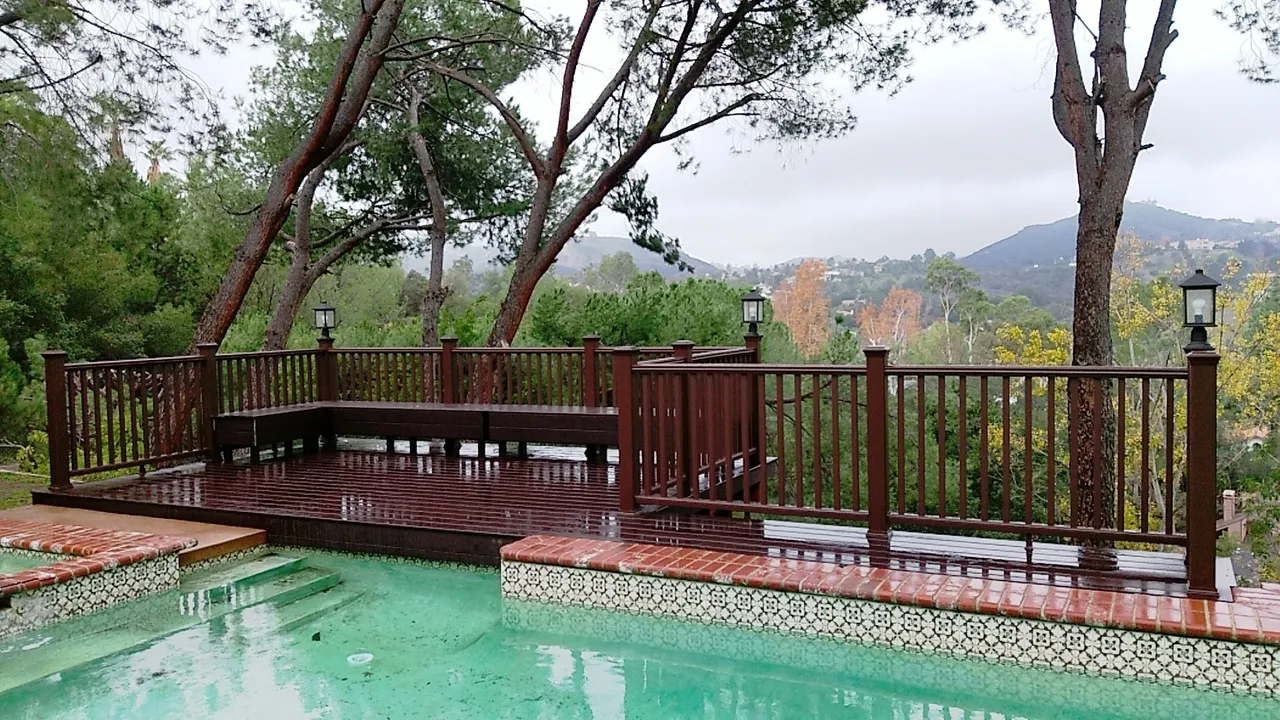 Scenic wooden deck overlooking a rain-soaked pool.