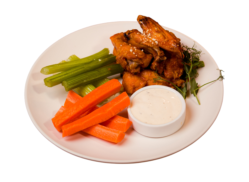 Plate of chicken wings with celery, carrots, and dipping sauce