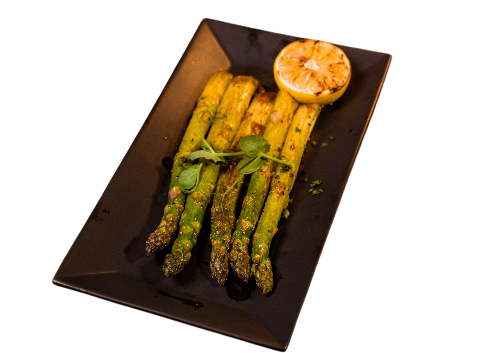Grilled asparagus with lemon on a black plate