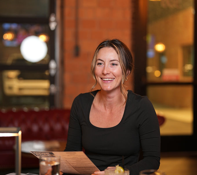 Woman smiling while reading a menu in a restaurant