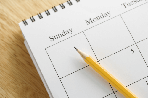 Close-up of open calendar with pencil indicating Sunday