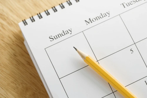 Close-up of open calendar with pencil indicating Sunday