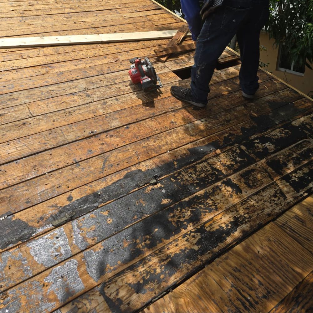 construction worker cutting wooden roof panels