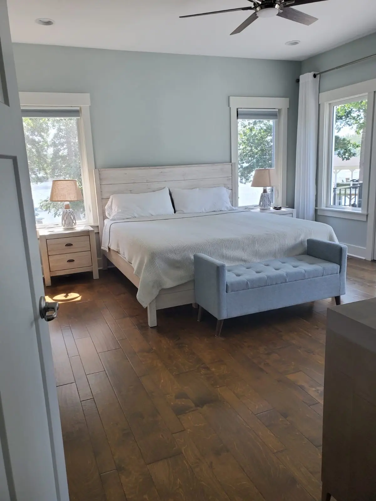 Modern bedroom with light blue walls and wood flooring