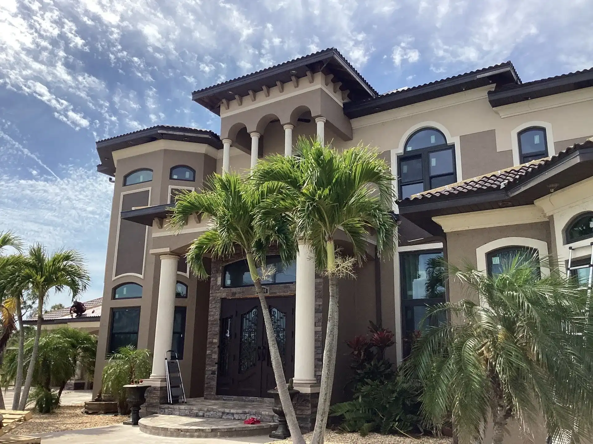 Luxurious modern mansion with palm trees and blue sky
