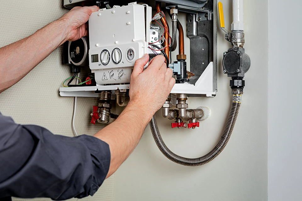 Technician repairing a heating system control unit.