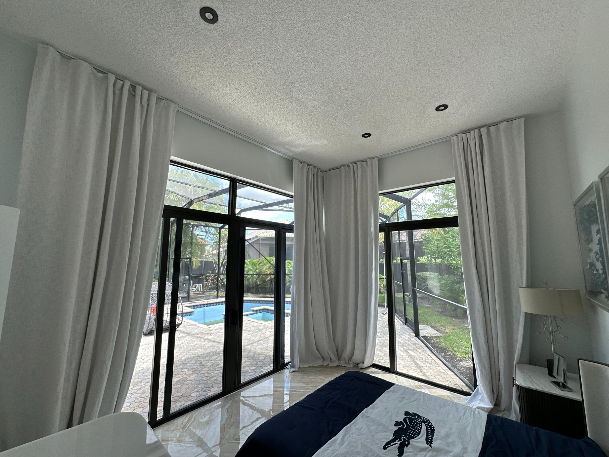 Modern bedroom with pool view through large windows