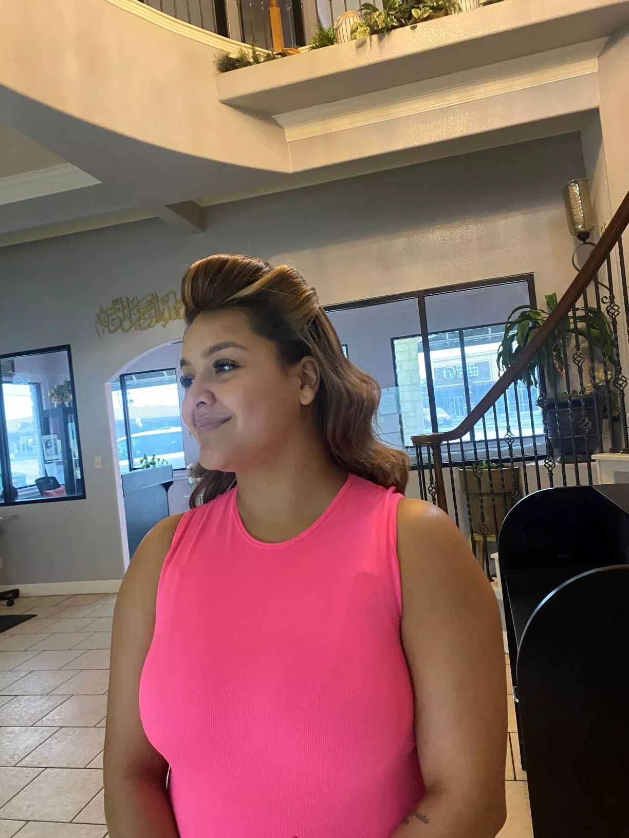 Woman in pink top smiling indoors