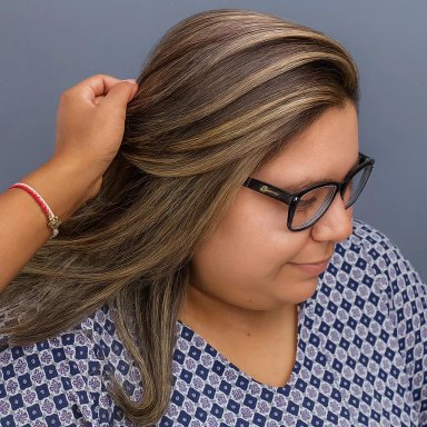 Woman with highlighted hair receiving a hair styling treatment