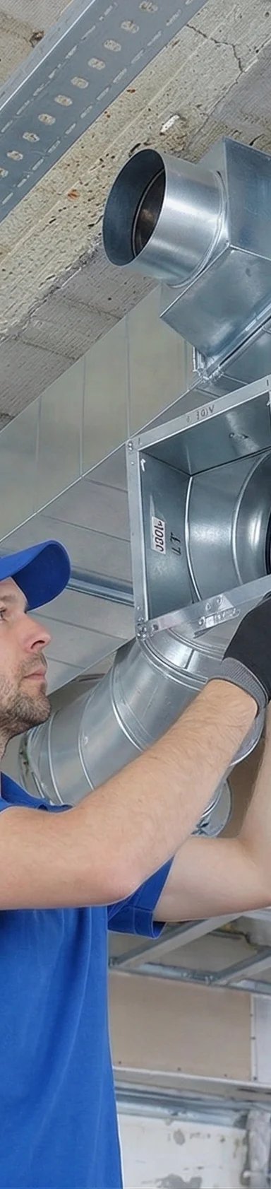 Worker installing HVAC ductwork in a ceiling