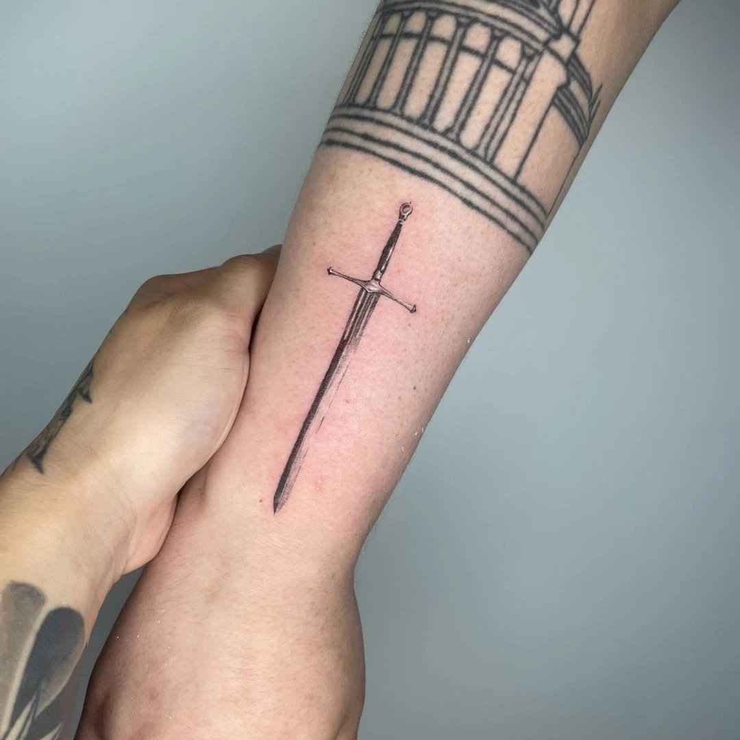 Detailed tattoo of a sword on the forearm
