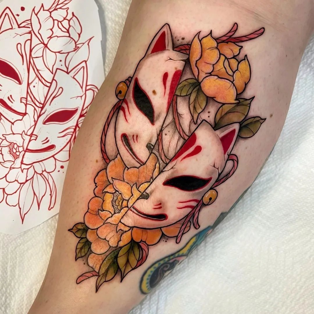 Tattoo featuring fox masks with flowers on an arm