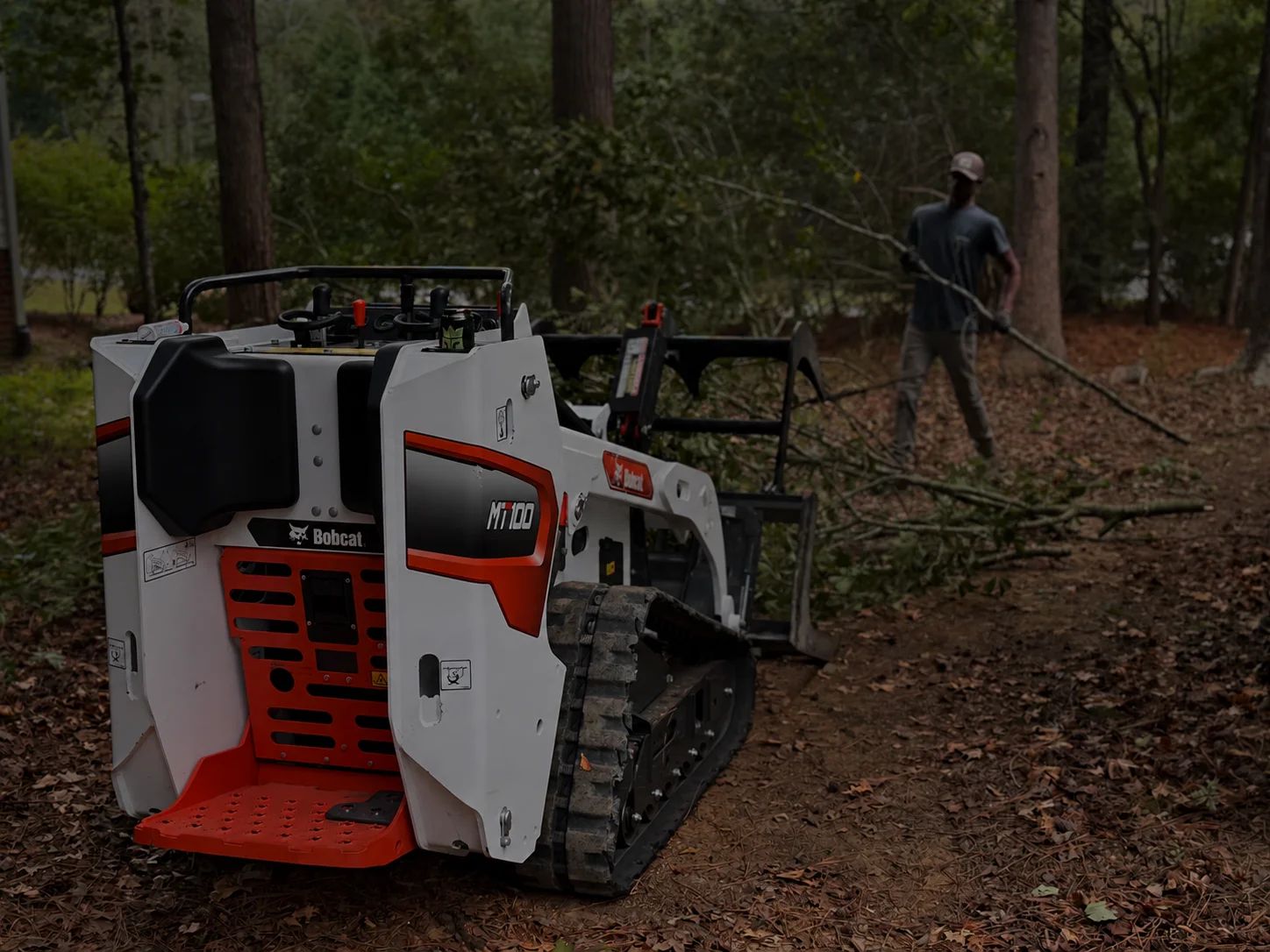 Bobcat mini skid steer working in a wooded area