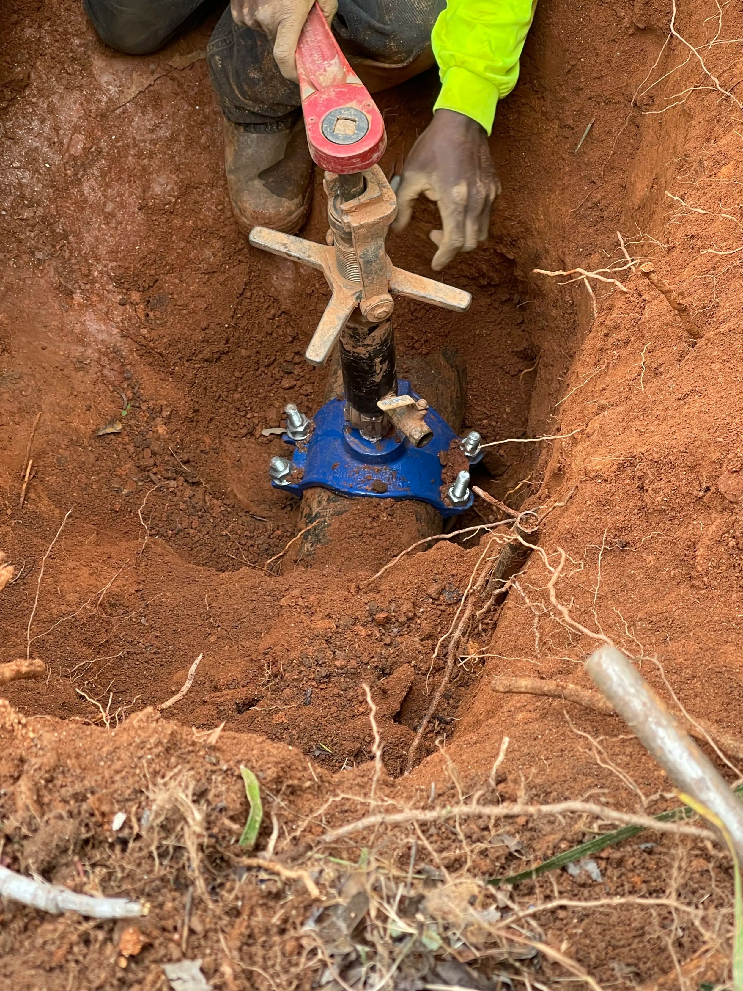 Worker using a tool in a deep hole for construction.