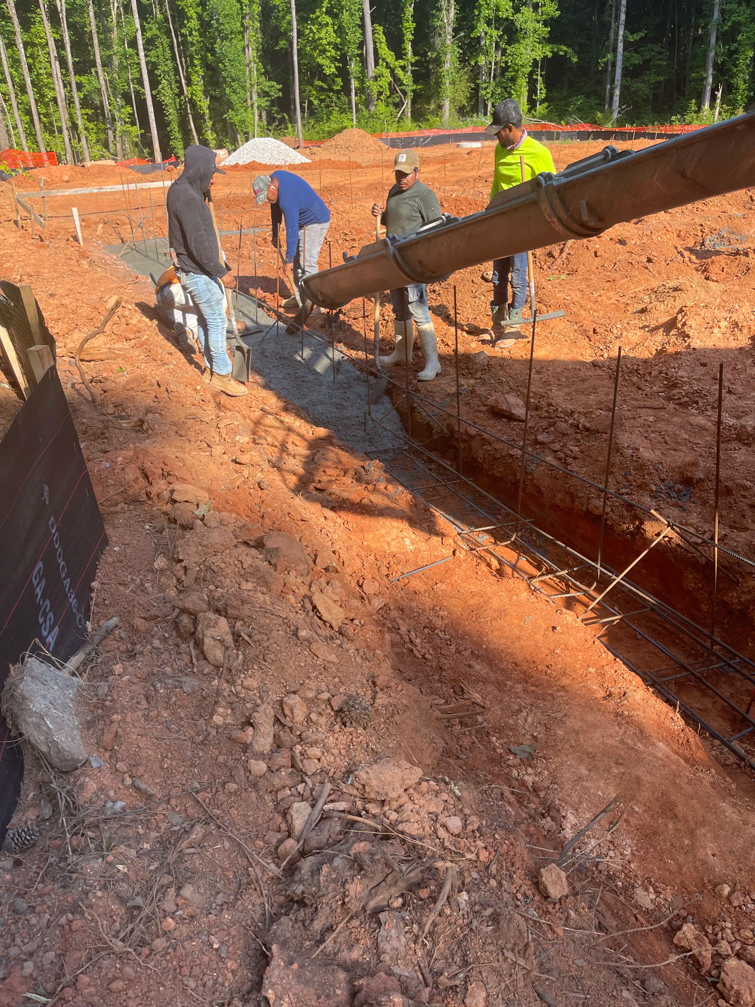 Construction workers pouring concrete into a foundation.