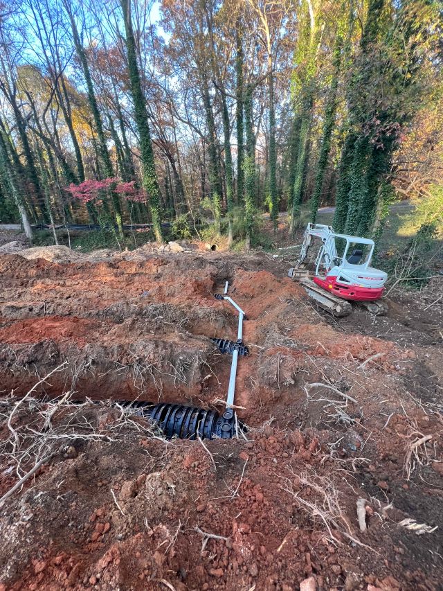 Construction site featuring drainage installation with machinery