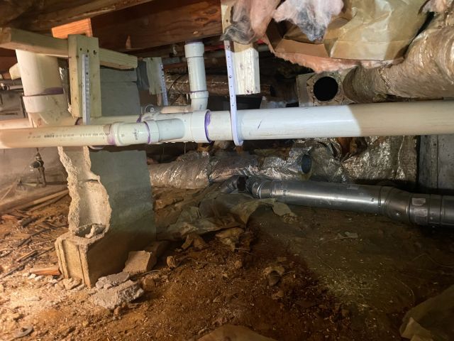 PVC pipes and plumbing in a crawl space
