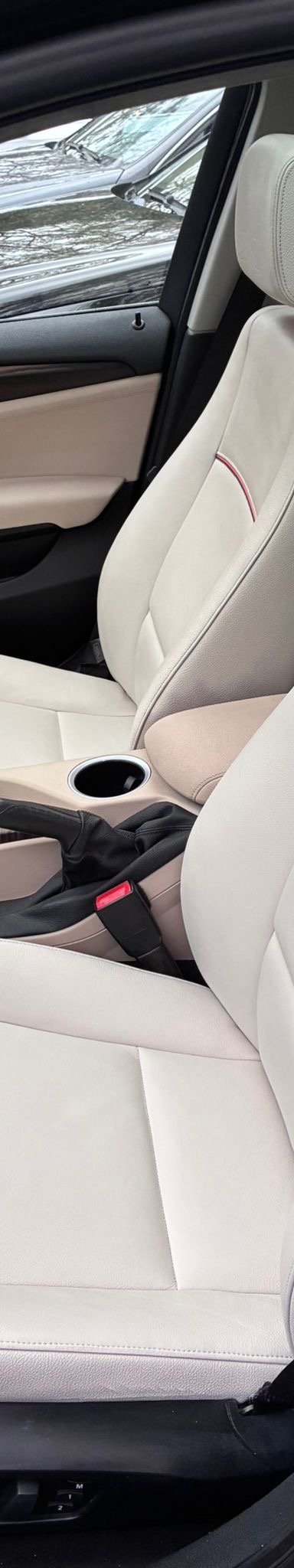 Interior view of a BMW car featuring beige leather seats