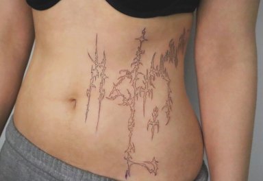 Abstract tattoo design on a person's abdomen