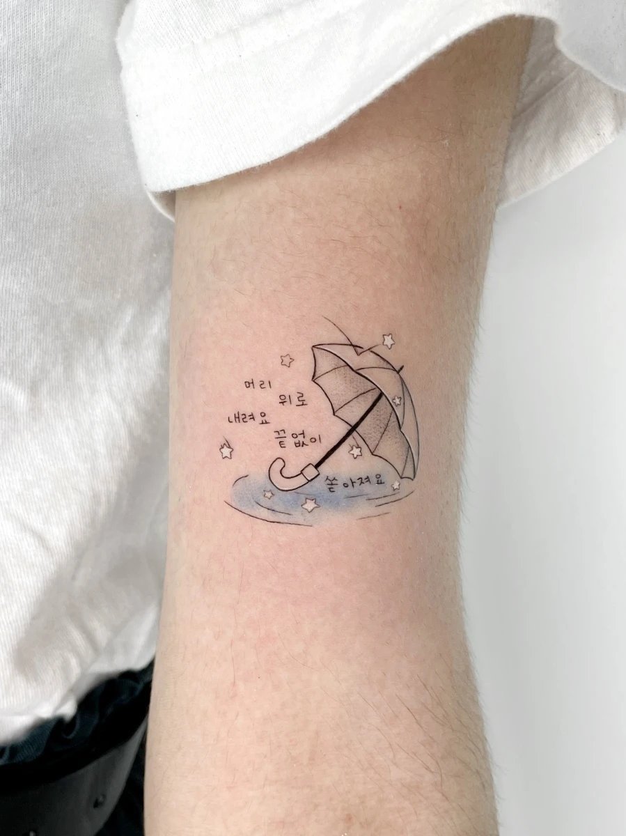 Tattoo of an umbrella over water, with text in Korean
