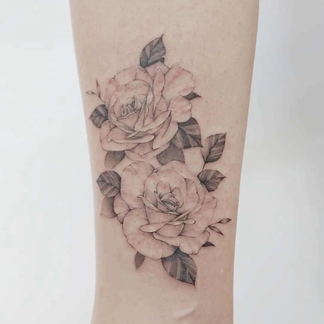 Delicate tattoo of two roses on a forearm