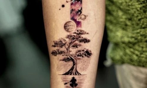 A detailed tattoo of a tree surrounded by cosmic elements on a forearm.