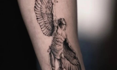 Detailed tattoo of a muscular winged figure on forearm