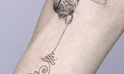 Detailed tattoo of a sleeping tiger on a forearm