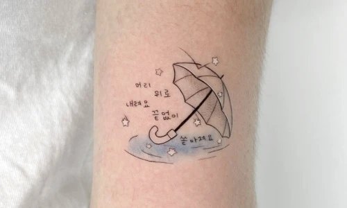 Tattoo of an umbrella on an arm with stars