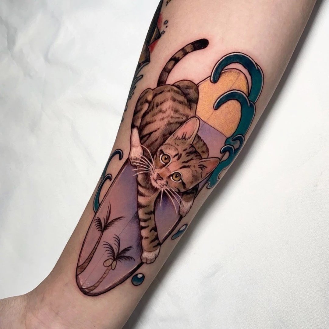 Tattoo of a tabby cat emerging from waves.