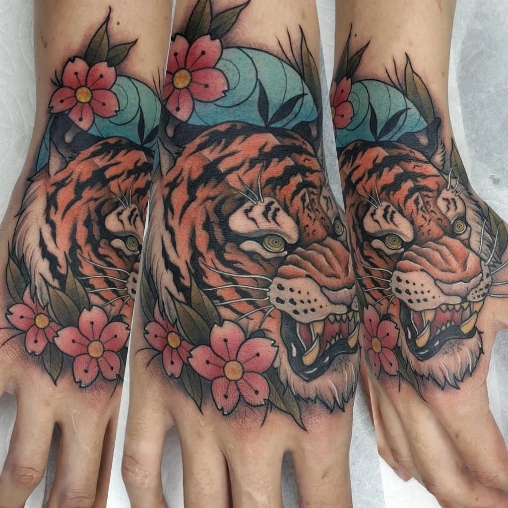 Colorful tiger tattoo featuring flowers on hands.
