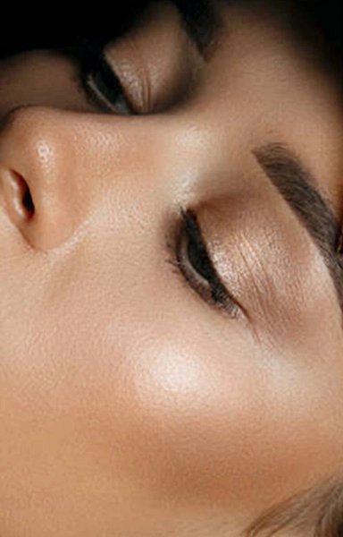 Woman receiving eyebrow microblading treatment