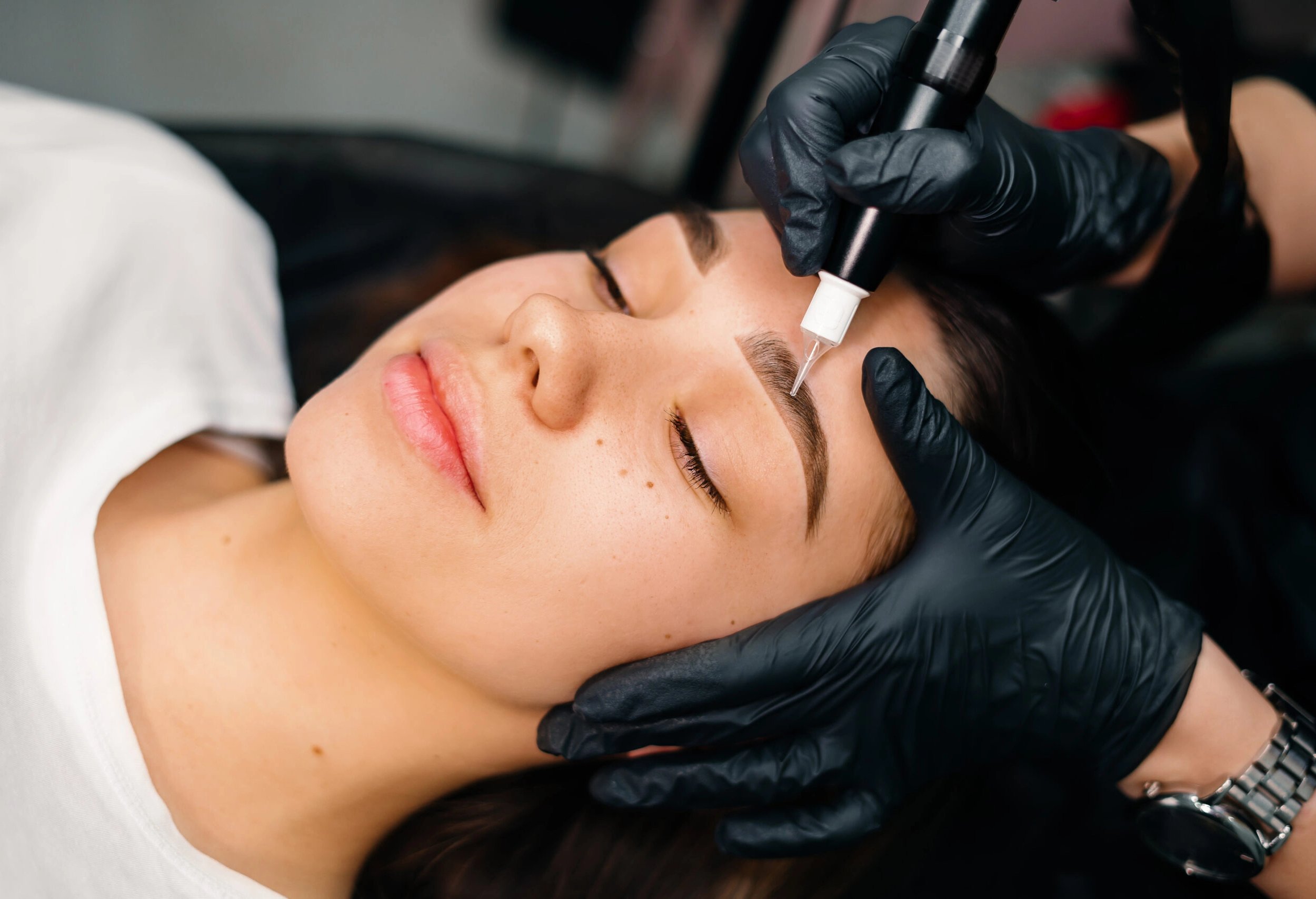 Professional eyebrow microblading procedure on a client.