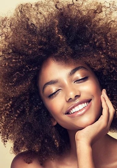 Smiling woman with curly hair on a neutral background