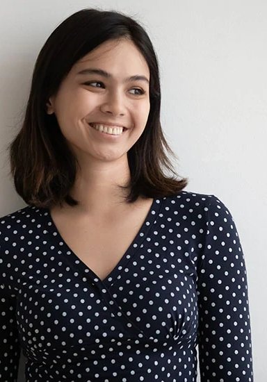 Smiling woman with dark hair in a polka dot dress