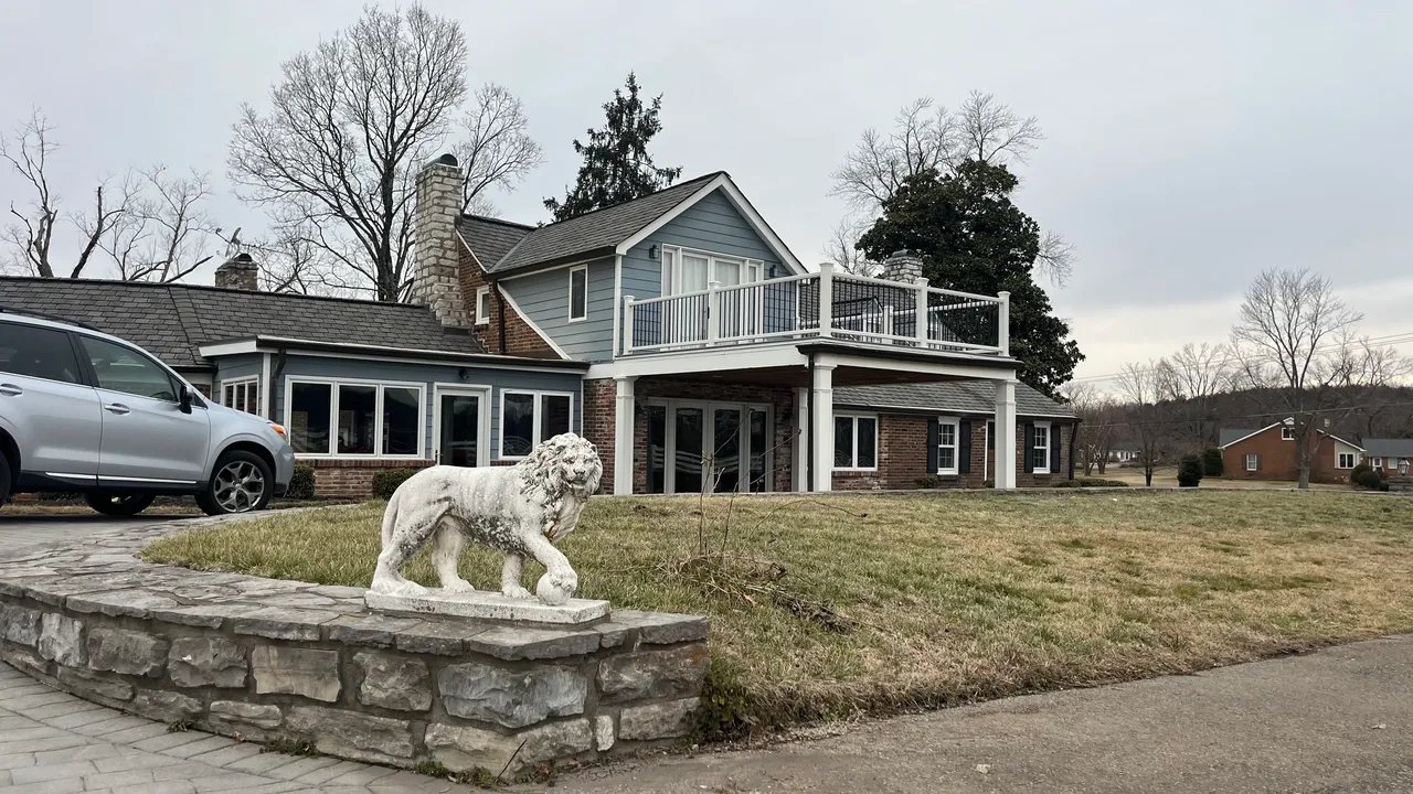 A large modern house with a lion statue in front