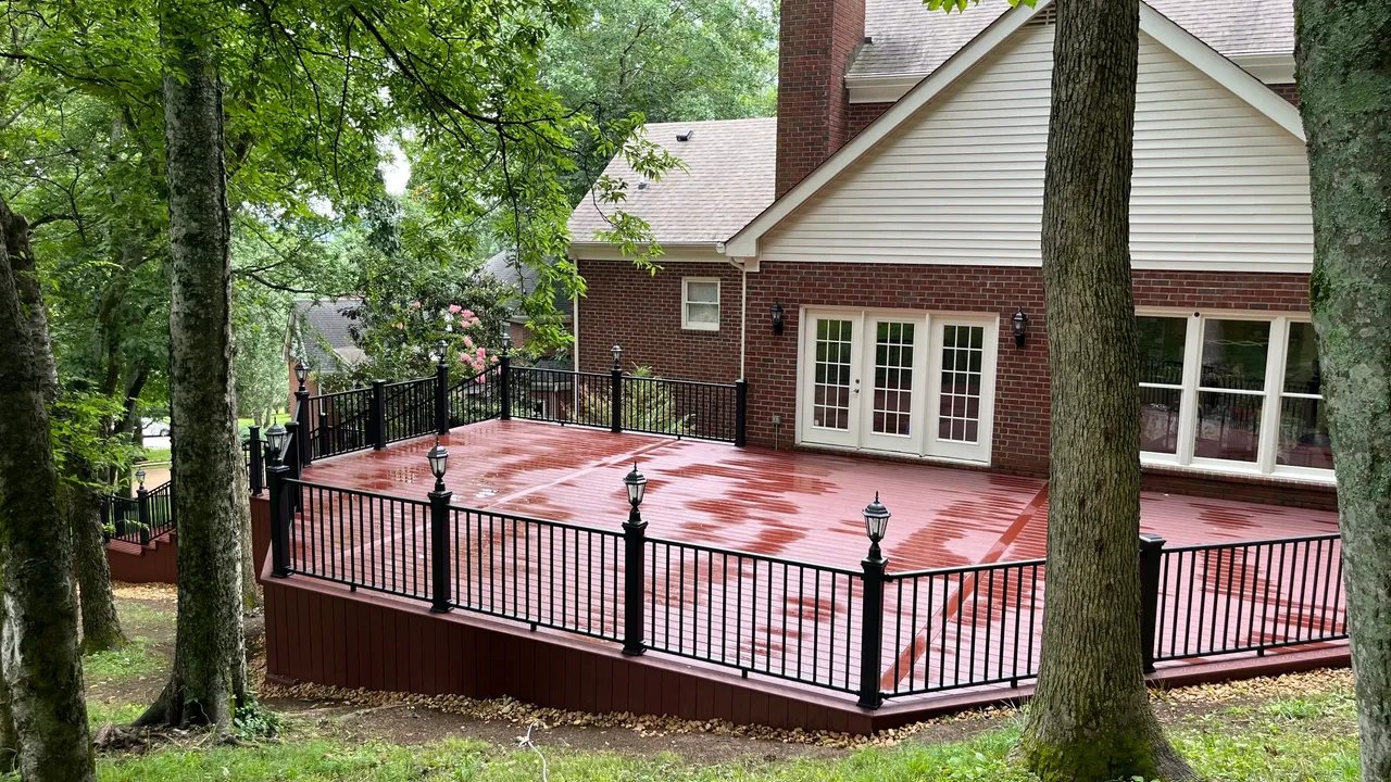 Red wooden deck with black railing and lampposts