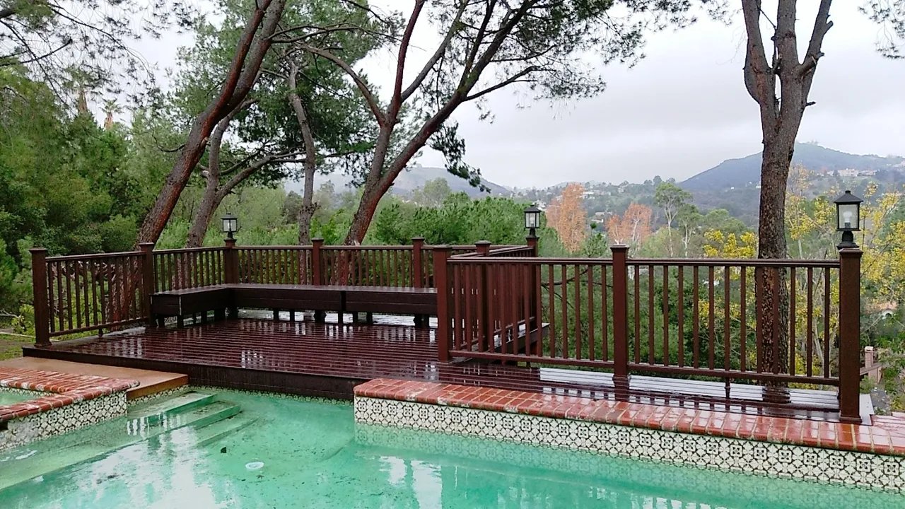 Scenic wooden deck overlooking a rain-soaked pool.