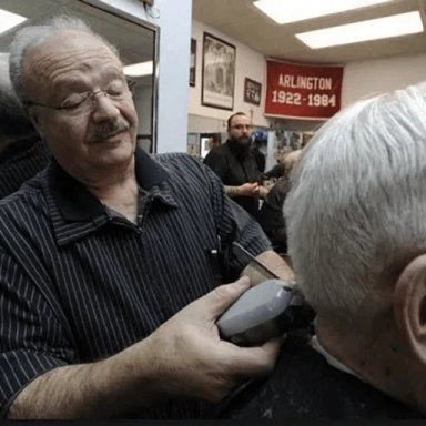 Barber cutting a client's hair in a salon